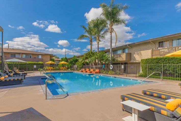 A community pool with yellow umbrellas