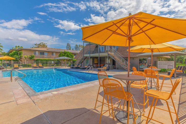 Yellow chairs and umbrellas next to the community pool