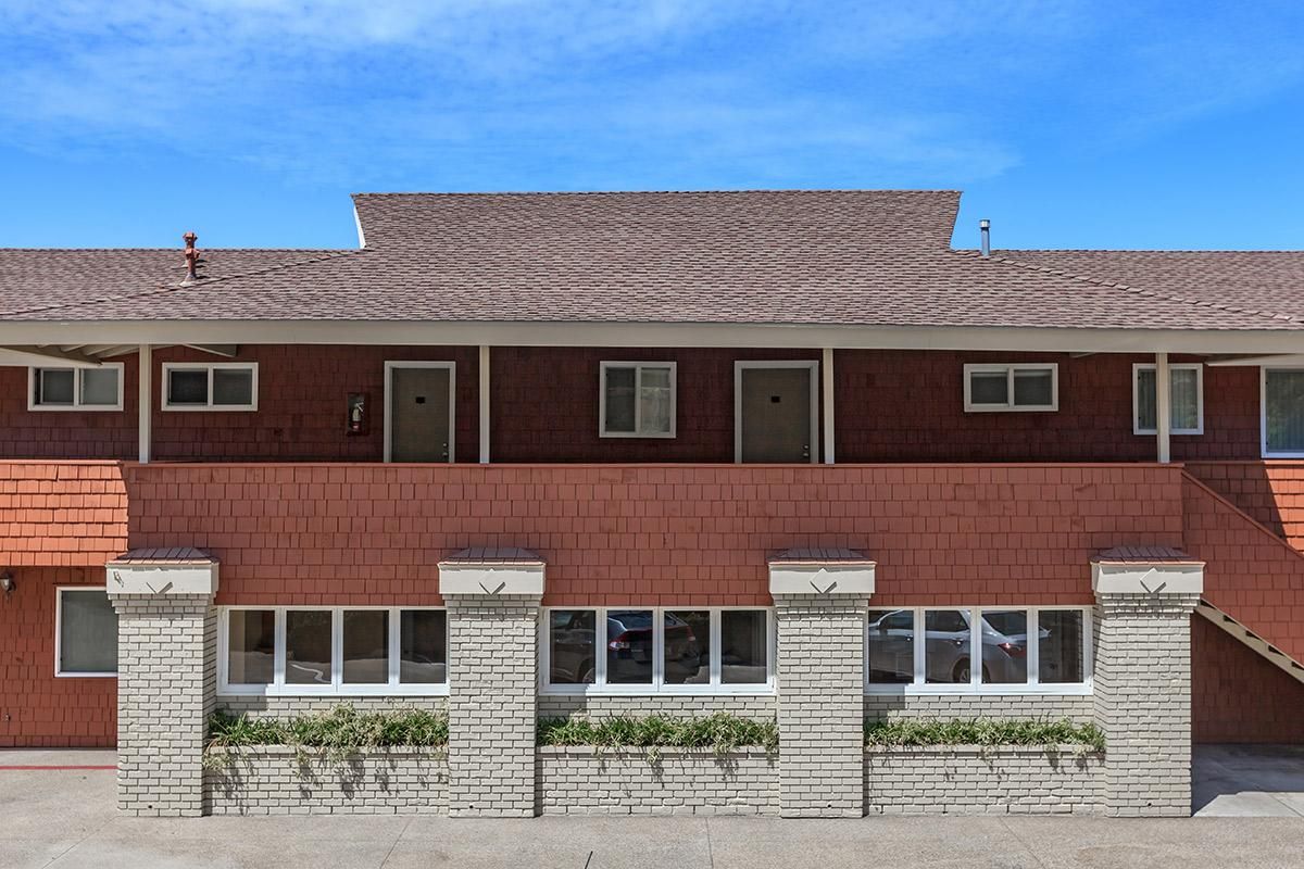 a large brick building with grass in front of a house