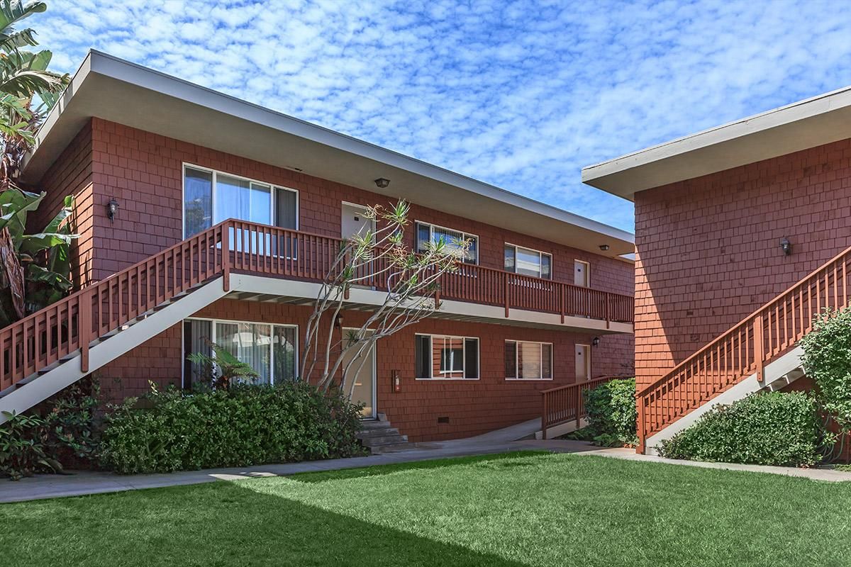 a house with a lawn in front of a brick building