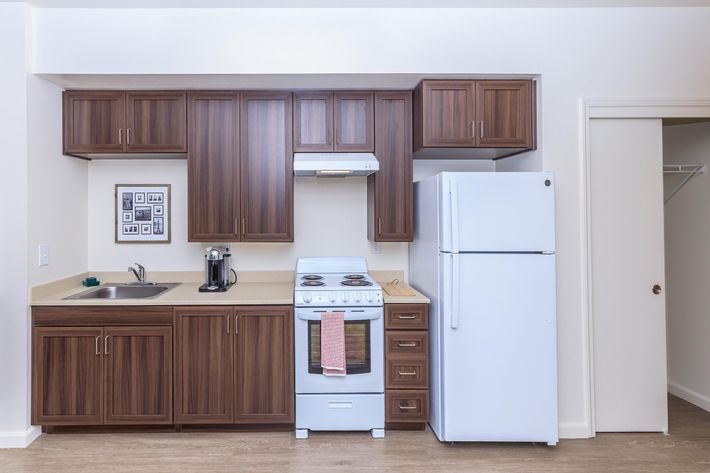 Apartments Daly City-Brunswick Street Kitchen with Modern Lighting, Matching White Appliances, and Hardwood Styled Floors