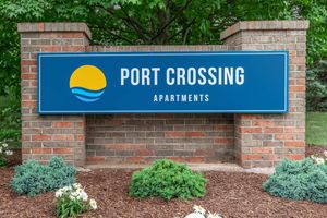 Brick monument sign with blue Port Crossing sign