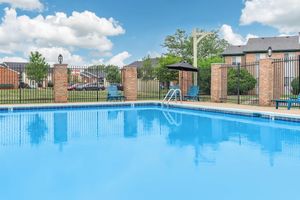 Fenced in swimming pool with seating at Port Crossing Apartments in Portage, Indiana