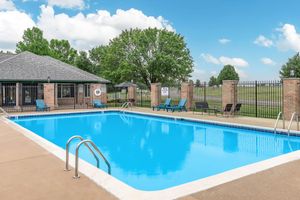 Fenced in swimming pool with seating at Port Crossing Apartments in Portage, Indiana