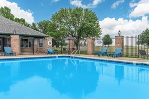 Fenced in swimming pool with seating at Port Crossing Apartments in Portage, Indiana