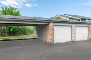 Covered parking spots with white garage doors  at Port Crossing Apartments in Portage, Indiana