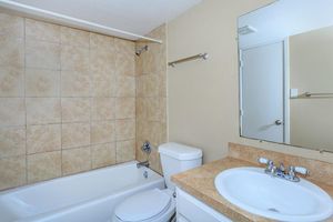 a white sink sitting under a mirror