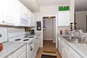 furnished kitchen with white cabinets