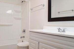 a white sink sitting under a mirror