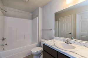 a white sink sitting under a mirror