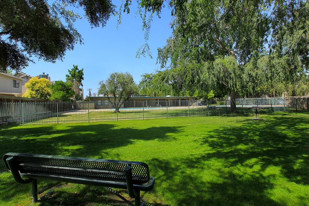 barbecue grill and bench with gated pool.