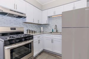 a stove top oven sitting inside of a kitchen