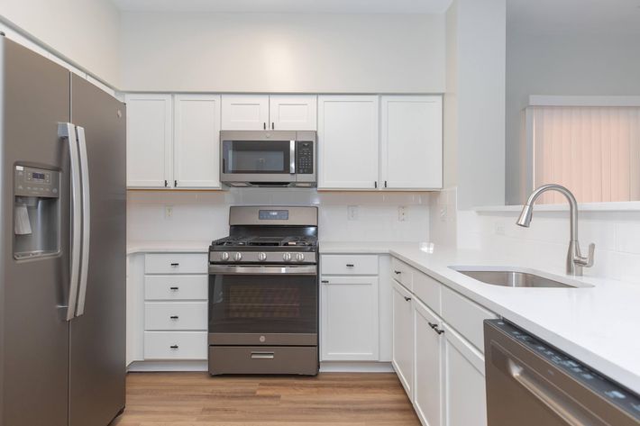 a kitchen with stainless steel appliances and wooden cabinets