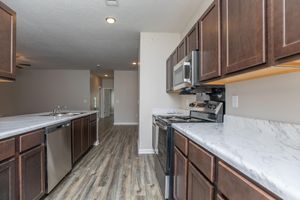 a large kitchen with stainless steel appliances and wooden cabinets