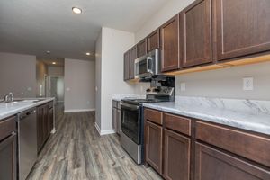 a large kitchen with stainless steel appliances and wooden cabinets