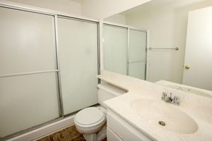 a white sink sitting under a mirror