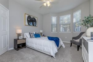 a bedroom with a bed and desk in a room