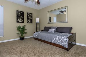 a bedroom with a bed and desk in a room