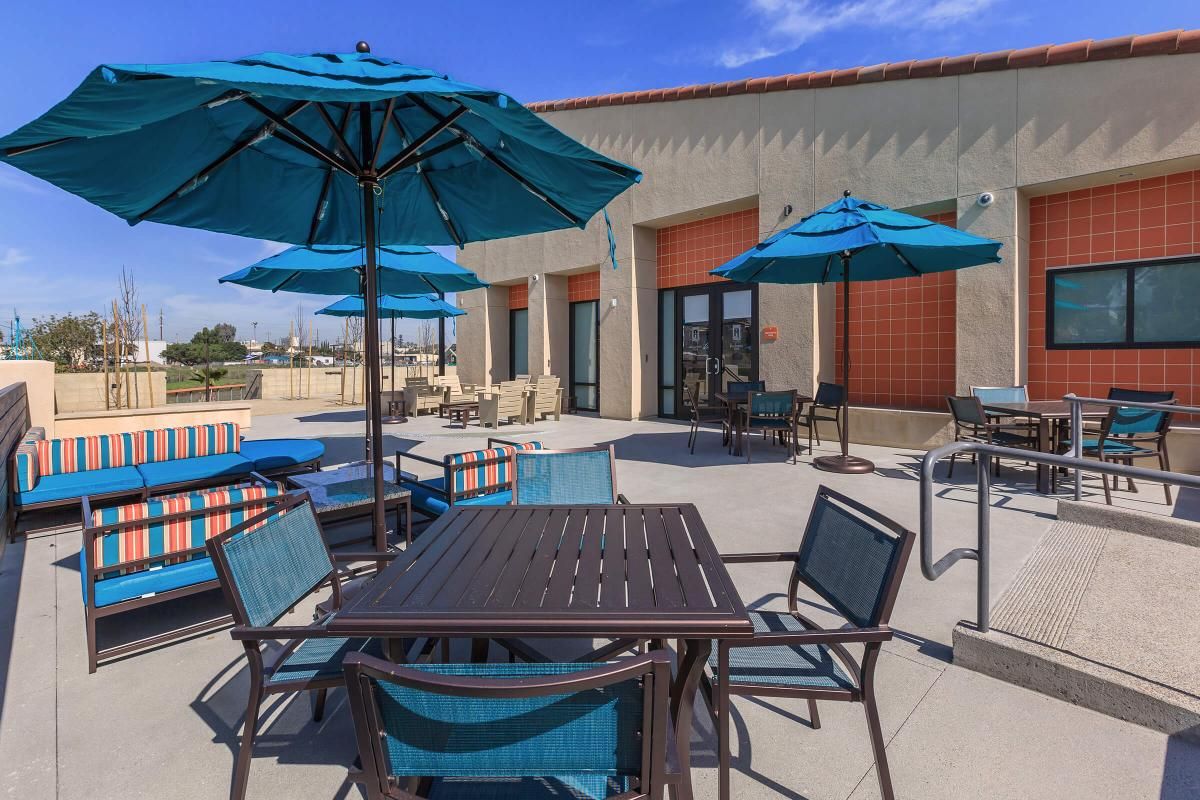 Tables and chairs under blue umbrellas