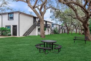 a couple of lawn chairs sitting on a bench in front of a house