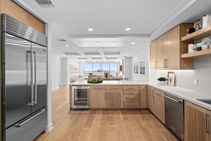 a modern kitchen with stainless steel appliances and wooden cabinets