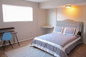 a bedroom with a bed and desk in a hotel room