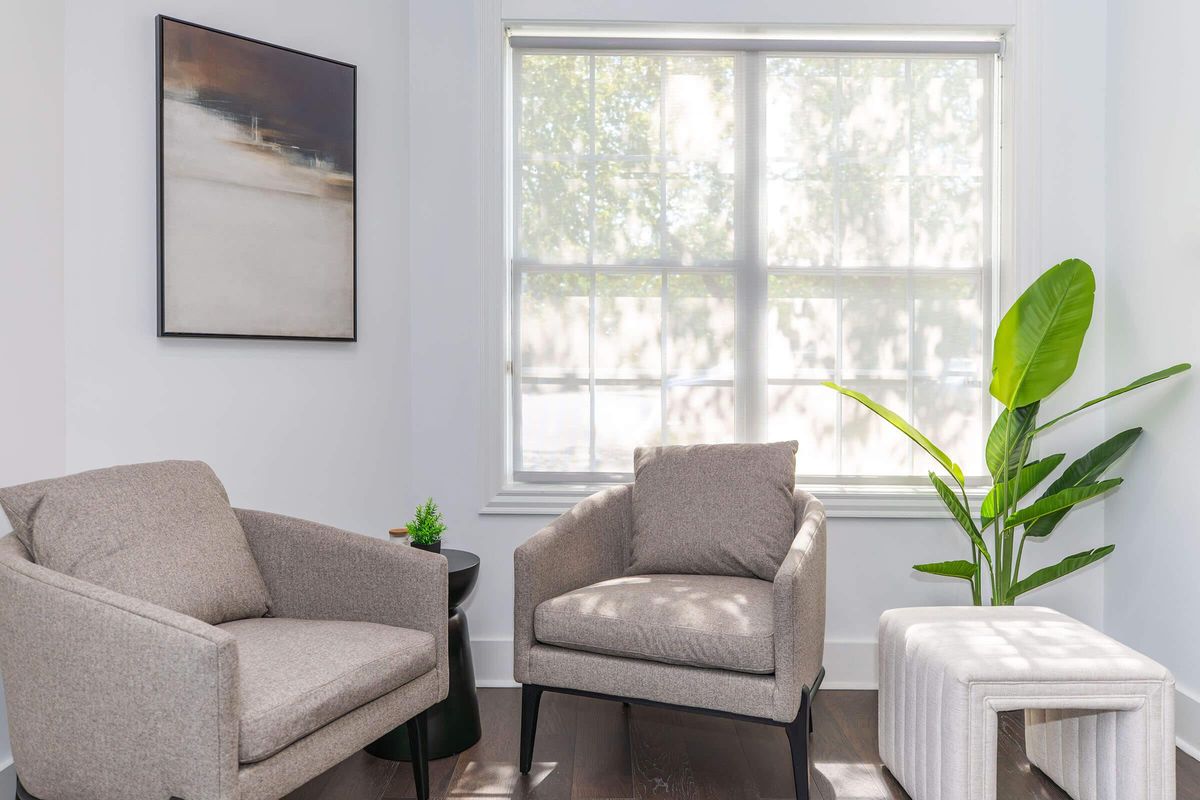 a living room filled with furniture and vase of flowers on a table