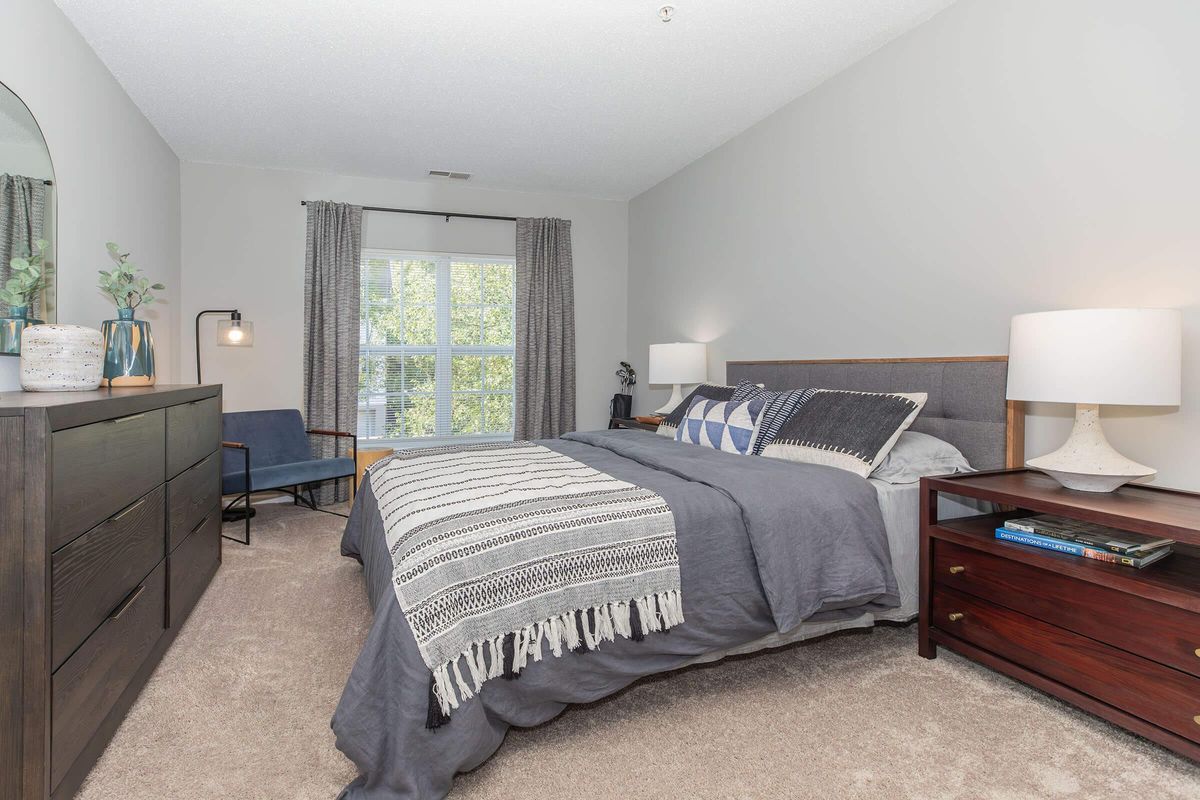 a bedroom with a bed and desk in a hotel room