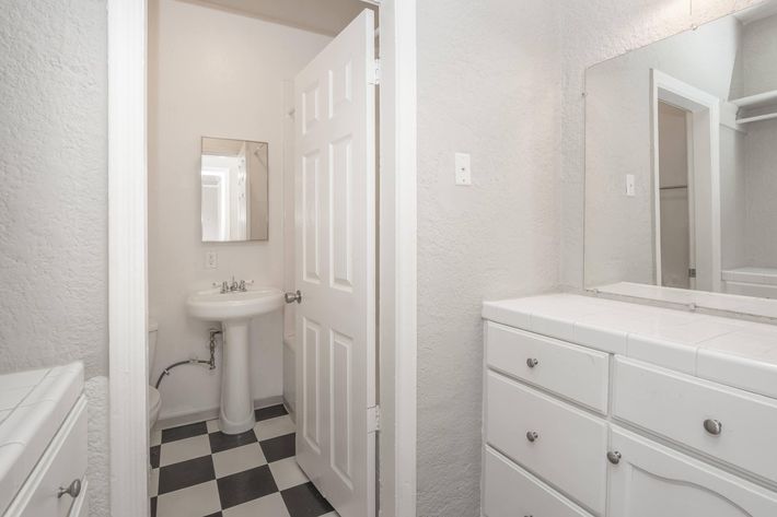 a white sink sitting under a mirror