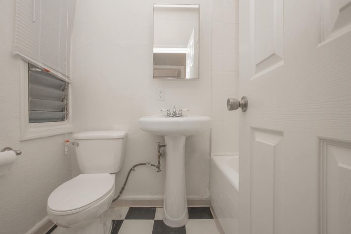 a white sink sitting under a mirror