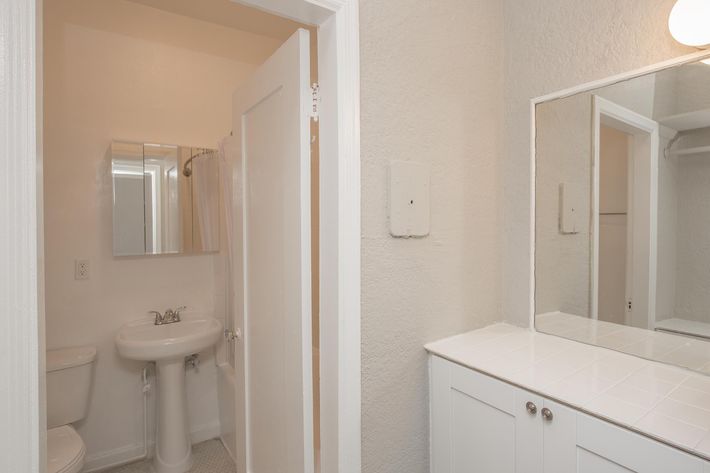 a white sink sitting under a mirror