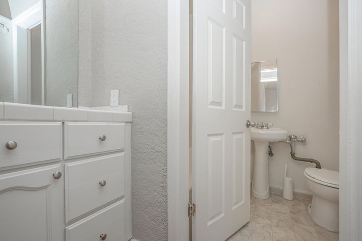 a white sink sitting under a mirror