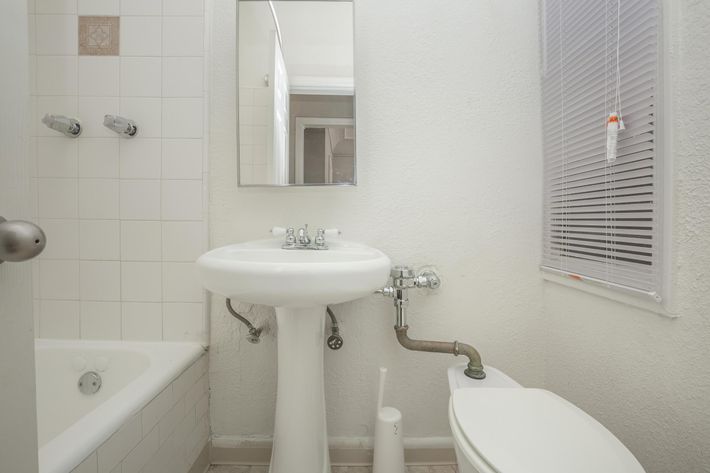 a white sink sitting under a mirror