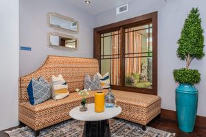 a living room filled with furniture and vase of flowers on a table