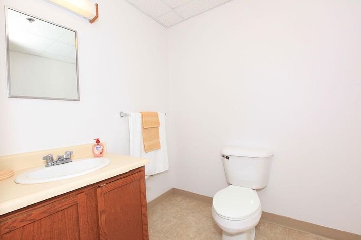 a white sink sitting under a mirror