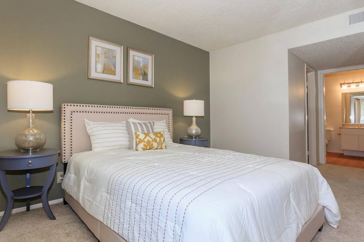 a bedroom with a bed and desk in a hotel room