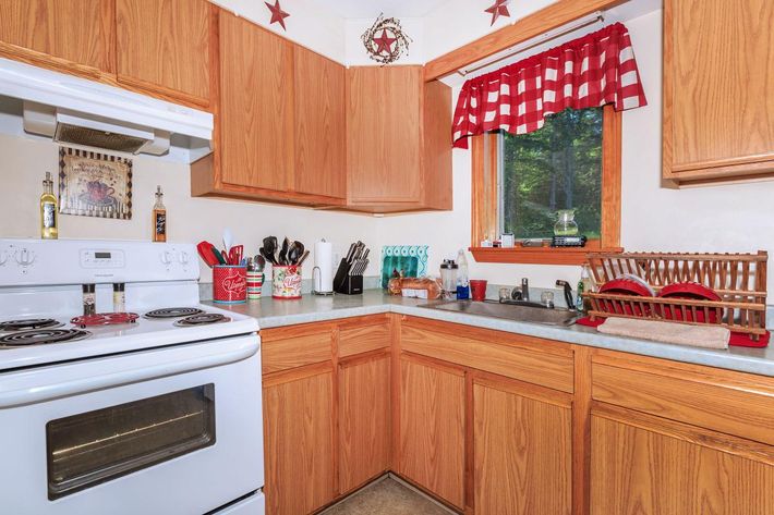 a kitchen with white appliances and wooden cabinets