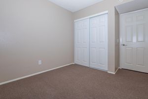 carpeted bedroom with sliding closet doors