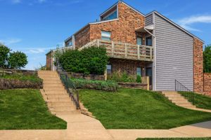 a large brick building with grass in front of a house