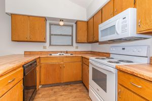 a kitchen with a stove refrigerator and wooden cabinets