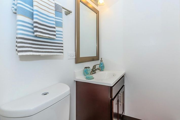 a white sink sitting under a mirror