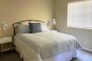 a bedroom with a bed and desk in a hotel room