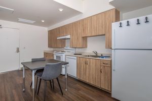 a kitchen with a refrigerator and table in a room