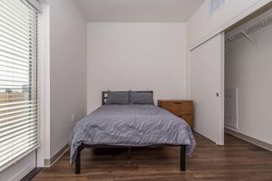 a bedroom with a bed and desk in a room