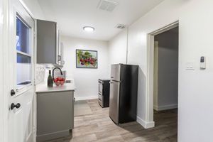 a living room with a sink and a refrigerator