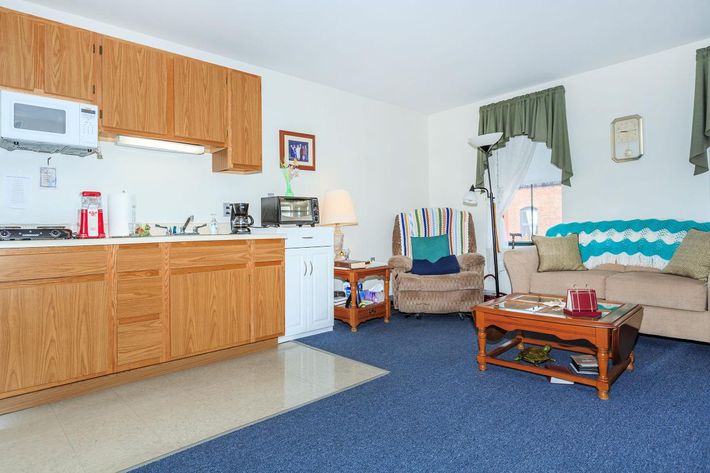 a living room filled with furniture and a refrigerator