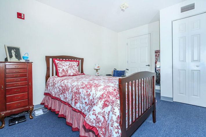 a bedroom with a bed and desk in a room