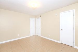 Unfurnished bedroom with closed closet and bathroom doors