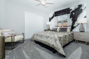 a bedroom with a bed and desk in a room