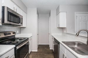 a kitchen with a stove a sink and a microwave